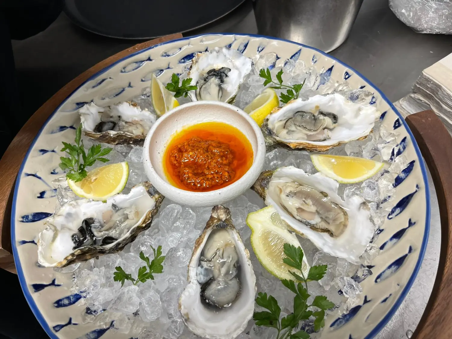 Eine Portion frische Austern auf Eis, dazu Zitronenspalten und eine Dip-Sauce. Von Nicchia GmbH